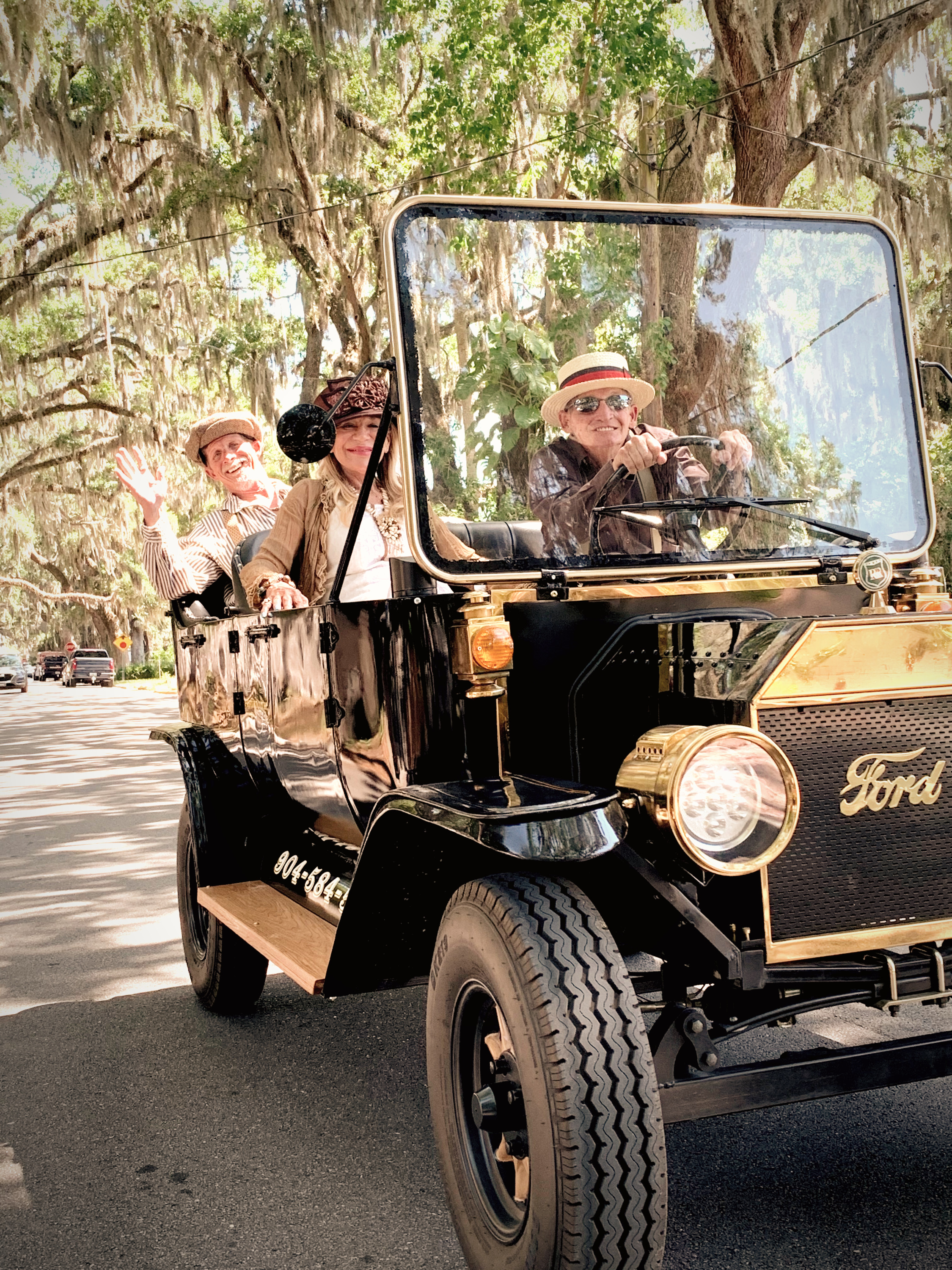 Pastime Tours guests riding in a black electric replica Model T